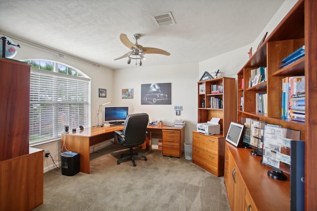 carpeted home office featuring ceiling fan and a textured ceiling