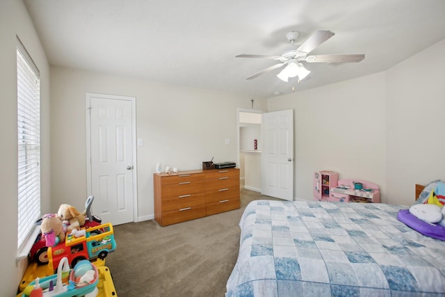 carpeted bedroom featuring multiple windows and ceiling fan