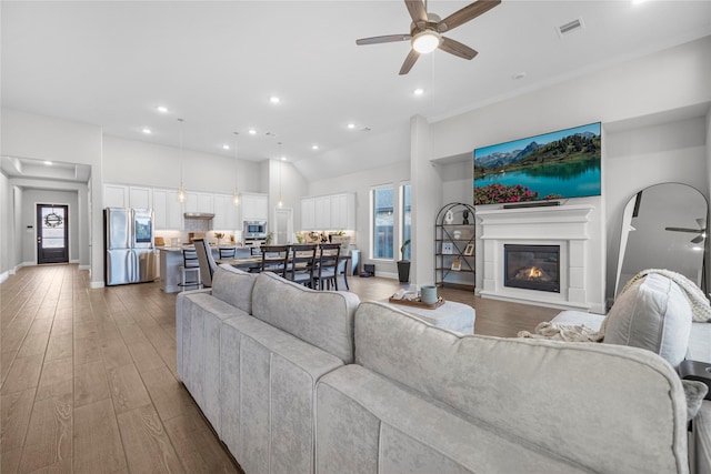 living room featuring wood-type flooring and ceiling fan