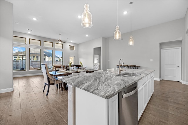 kitchen featuring hanging light fixtures, white cabinetry, dishwasher, and sink