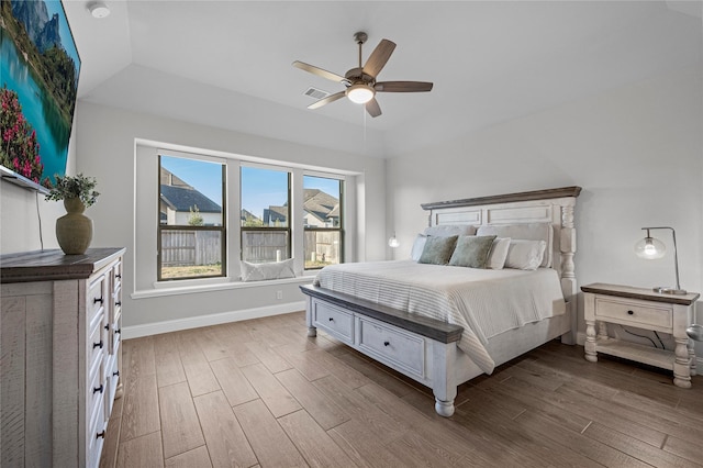 bedroom featuring hardwood / wood-style floors, ceiling fan, and a tray ceiling