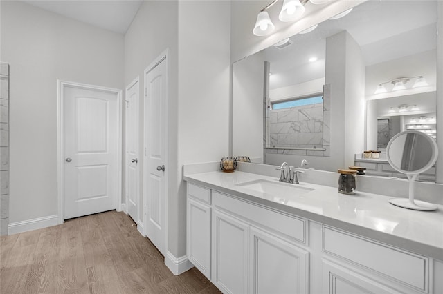 bathroom featuring hardwood / wood-style flooring, vanity, and a shower