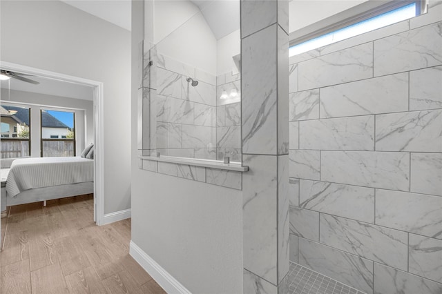 bathroom featuring ceiling fan, hardwood / wood-style floors, and a tile shower