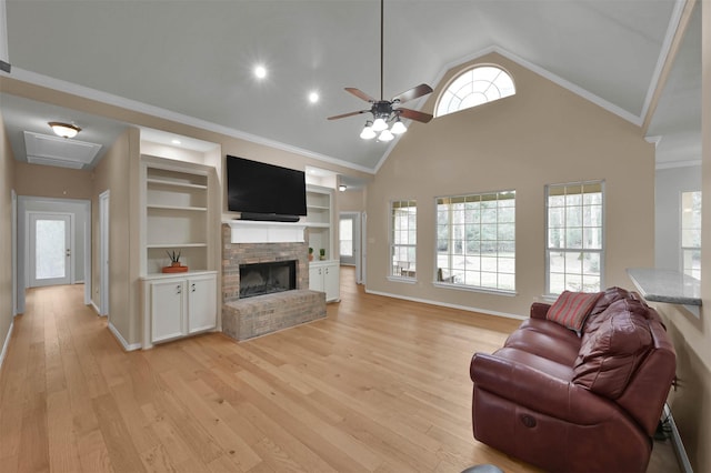 living room with ornamental molding, plenty of natural light, light wood-type flooring, and built in shelves