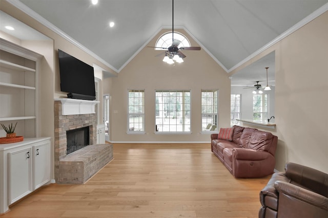 living room featuring light hardwood / wood-style flooring, ceiling fan, ornamental molding, a brick fireplace, and vaulted ceiling