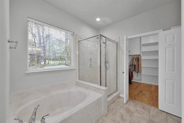 bathroom featuring shower with separate bathtub