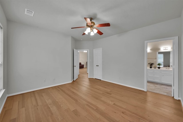 unfurnished bedroom featuring sink, connected bathroom, and light hardwood / wood-style floors