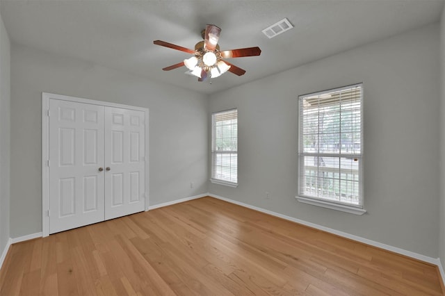 unfurnished bedroom featuring light hardwood / wood-style floors, a closet, and ceiling fan