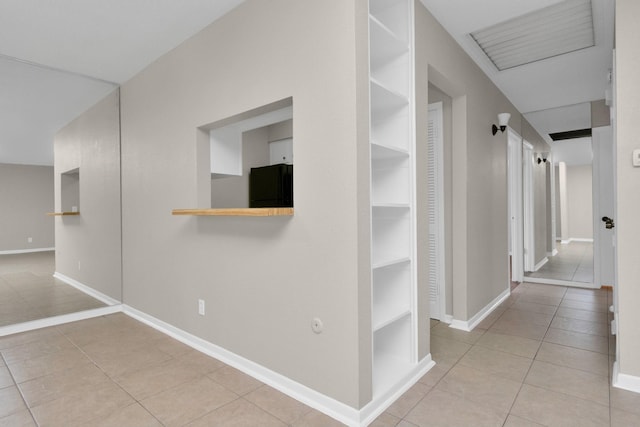 hall featuring light tile patterned floors