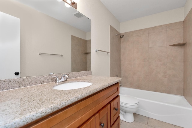 full bathroom featuring vanity, tiled shower / bath, tile patterned floors, and toilet