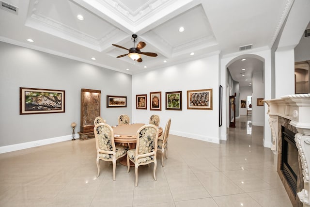 tiled dining space featuring beamed ceiling, crown molding, coffered ceiling, and ceiling fan