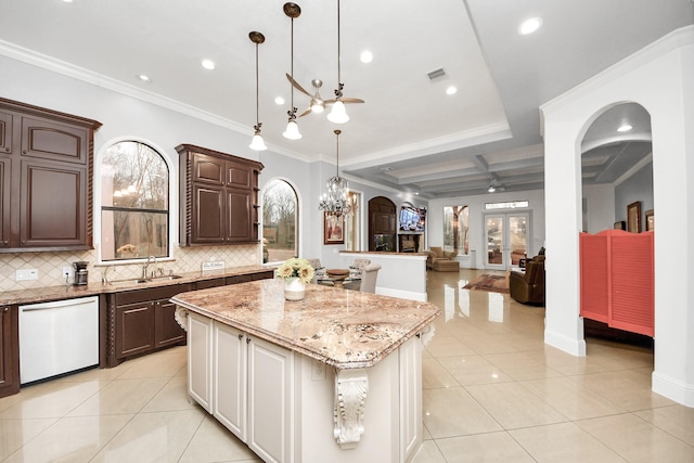 kitchen featuring white dishwasher, light tile patterned floors, decorative light fixtures, and a center island