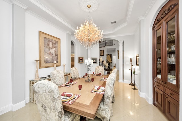 dining space featuring ornate columns, a chandelier, light tile patterned floors, a tray ceiling, and crown molding