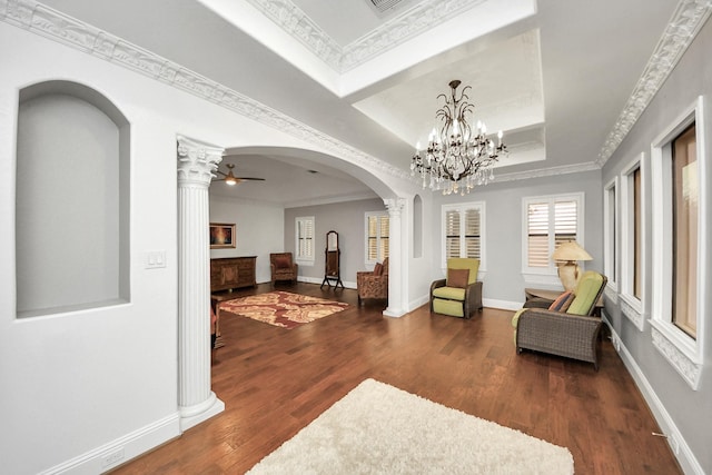 living area with crown molding, dark hardwood / wood-style floors, and ornate columns