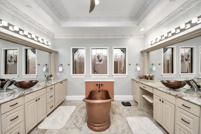 bathroom with crown molding, ceiling fan, a bathtub, vanity, and a tray ceiling