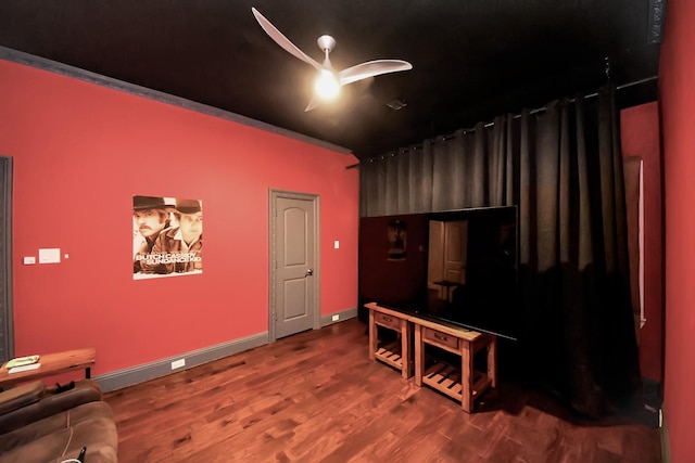 home theater room featuring hardwood / wood-style floors and ceiling fan