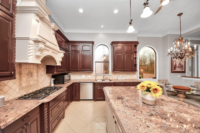 kitchen featuring custom exhaust hood, ornamental molding, appliances with stainless steel finishes, and decorative light fixtures