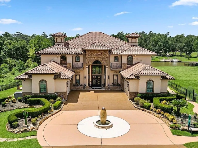 mediterranean / spanish home featuring a water view and a front lawn