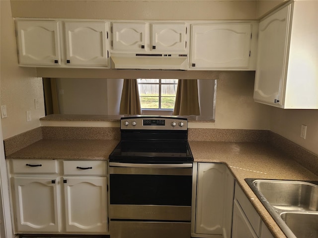 kitchen with stainless steel electric stove, sink, and white cabinets