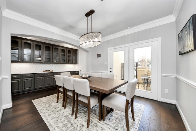 dining space featuring dark hardwood / wood-style flooring, crown molding, and french doors