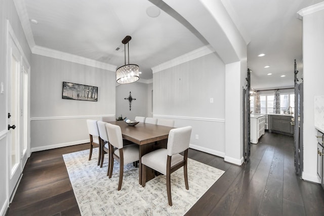 dining space featuring dark hardwood / wood-style flooring, a notable chandelier, and ornamental molding