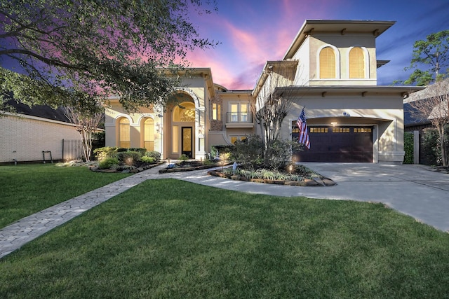 mediterranean / spanish-style house featuring a garage and a yard