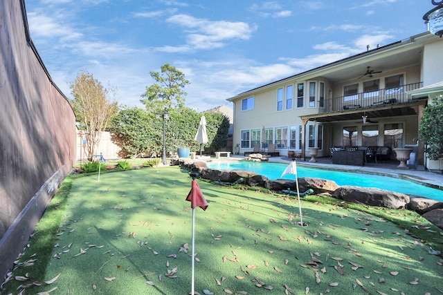 view of swimming pool featuring a patio and ceiling fan