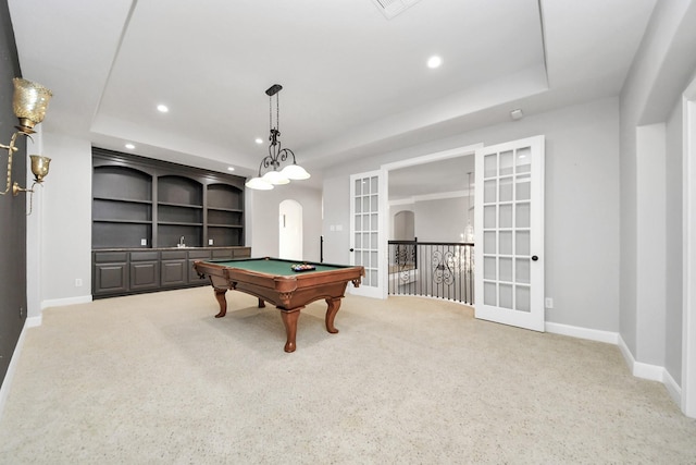 playroom featuring light carpet, a tray ceiling, french doors, and built in shelves