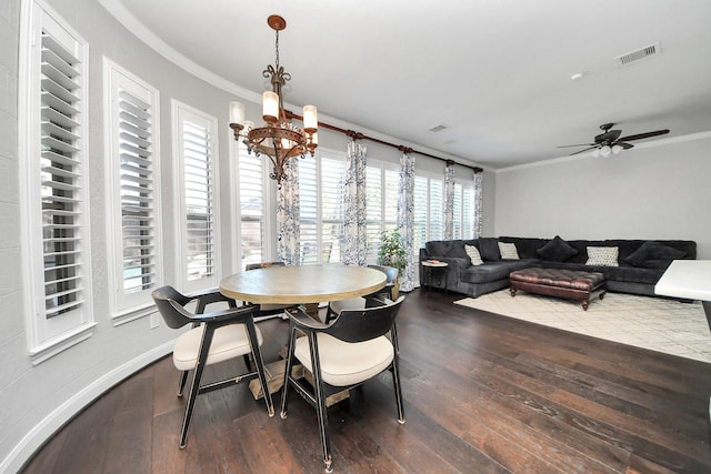 dining space with crown molding, dark wood-type flooring, and ceiling fan with notable chandelier