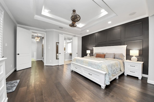 bedroom with crown molding, dark hardwood / wood-style floors, a raised ceiling, and an inviting chandelier