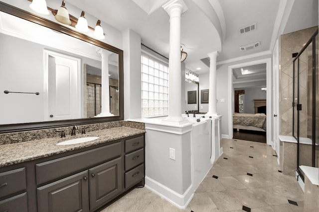 bathroom featuring ornate columns, vanity, crown molding, and a shower with shower door