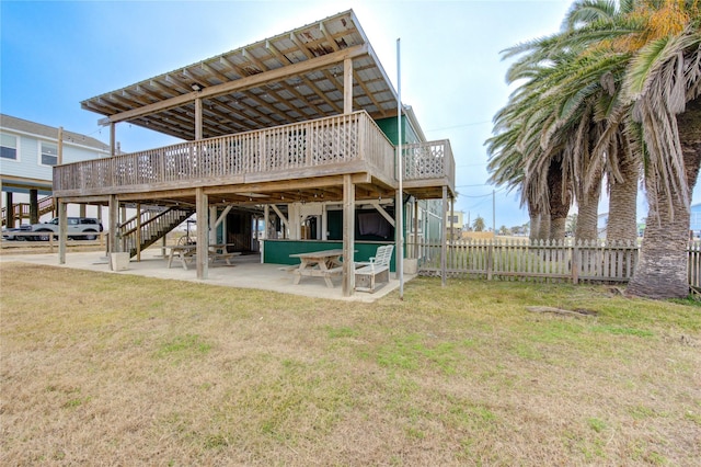 rear view of property with a patio, a deck, and a lawn