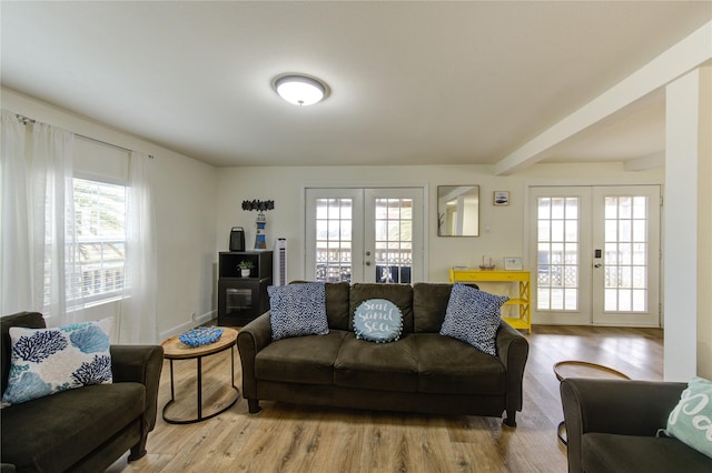 living room with french doors, beam ceiling, and light hardwood / wood-style flooring