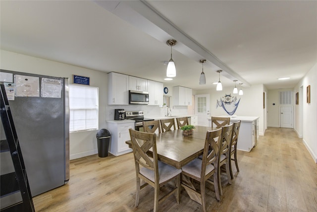 dining room with sink and light wood-type flooring