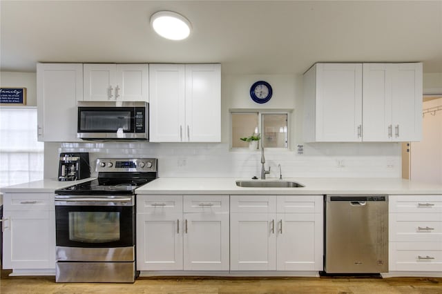 kitchen with white cabinetry, stainless steel appliances, and sink