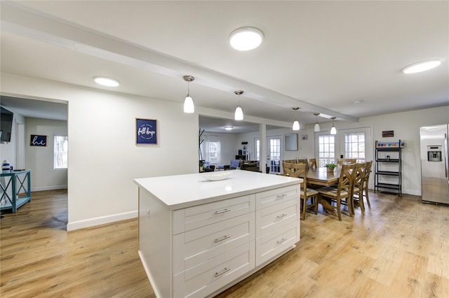 kitchen with pendant lighting, light hardwood / wood-style flooring, white cabinetry, a center island, and stainless steel fridge with ice dispenser