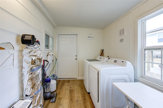 washroom featuring crown molding, washer and dryer, and light hardwood / wood-style floors