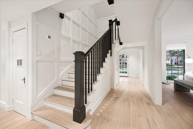 stairs with hardwood / wood-style flooring and plenty of natural light