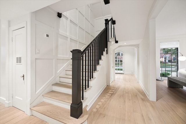 stairway featuring a wealth of natural light and hardwood / wood-style floors