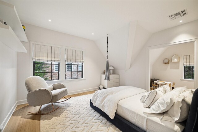 bedroom with vaulted ceiling and light hardwood / wood-style flooring