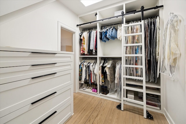 walk in closet with light wood-type flooring