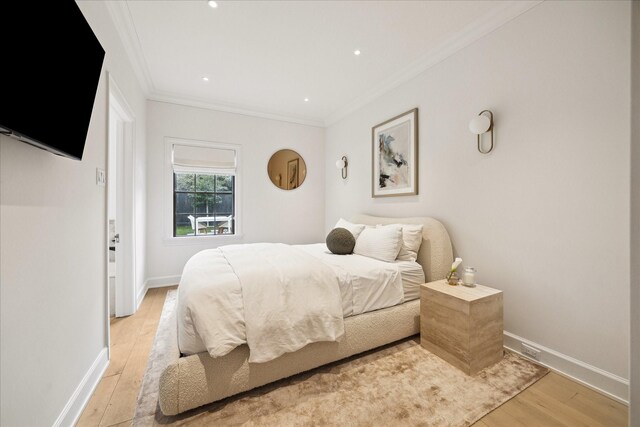 bedroom with crown molding and light wood-type flooring