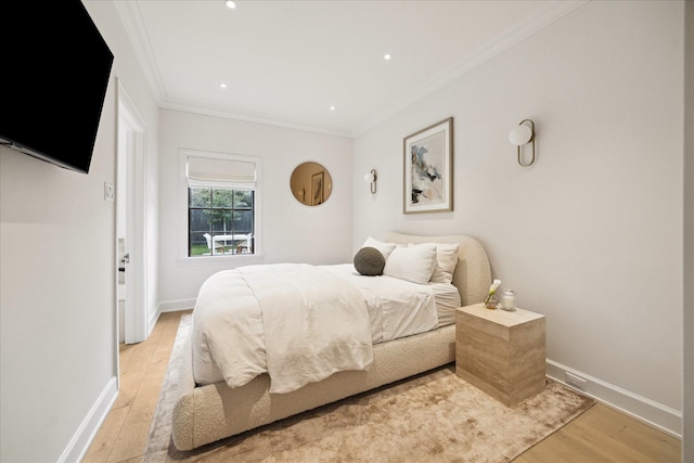 bedroom featuring crown molding and light hardwood / wood-style flooring