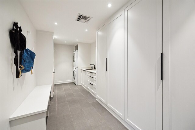 mudroom featuring sink and stacked washer / dryer