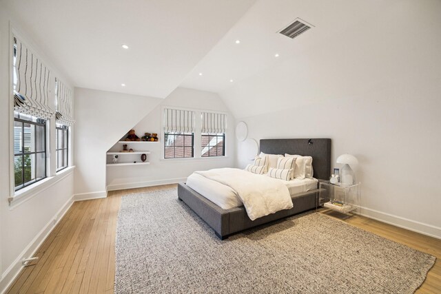 bedroom with vaulted ceiling and light hardwood / wood-style flooring