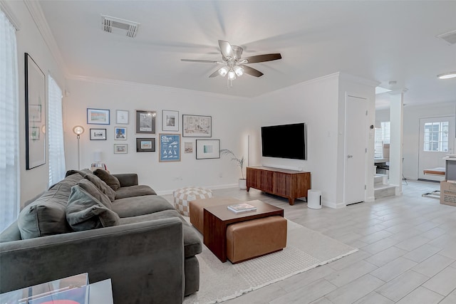 living room with crown molding, ceiling fan, light hardwood / wood-style floors, and ornate columns