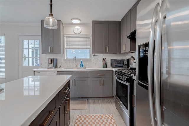 kitchen featuring pendant lighting, stainless steel appliances, sink, and tasteful backsplash