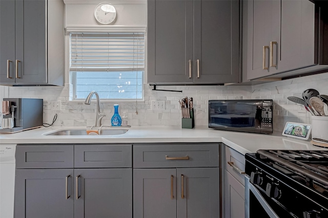 kitchen with backsplash, black appliances, sink, and gray cabinetry