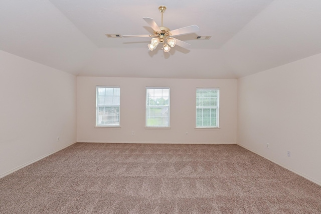 spare room with ceiling fan, light colored carpet, and vaulted ceiling