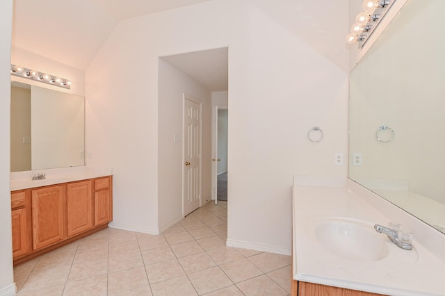 bathroom with tile patterned flooring, vanity, and lofted ceiling